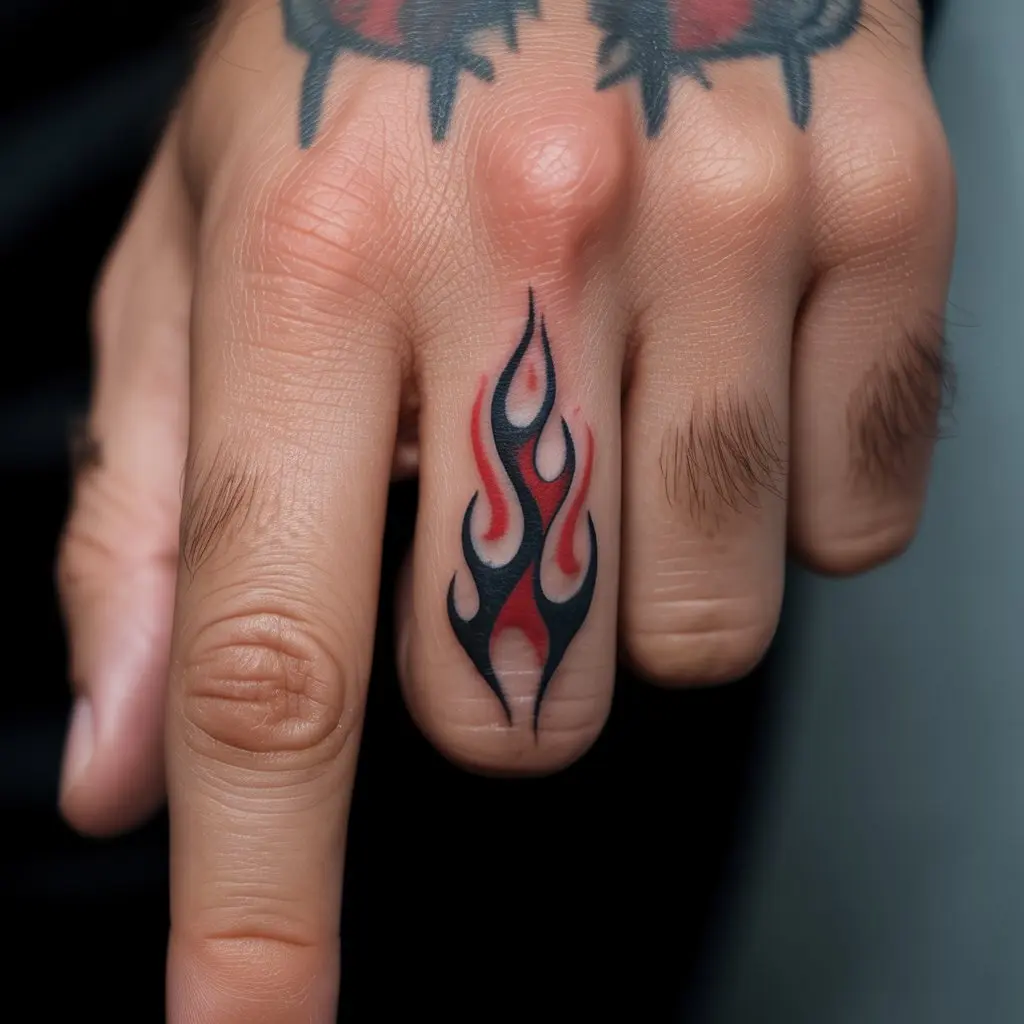 Red and Black Flame Tribal Finger Tattoo – Tribal flames in red and black on a man’s finger, fiery finger tattoos for men.

