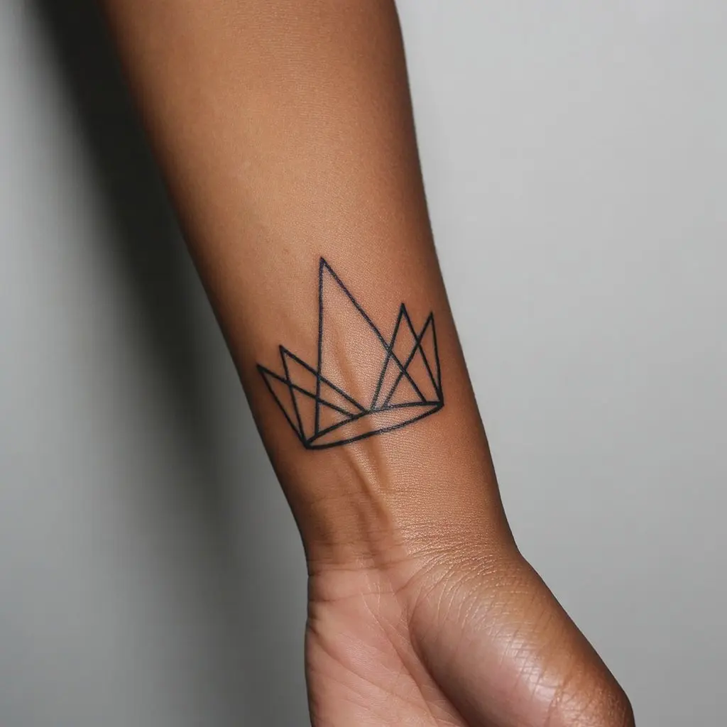 Black women tattoos – minimalist geometric crown tattoo on wrist, symbolizing modern elegance and regal identity.